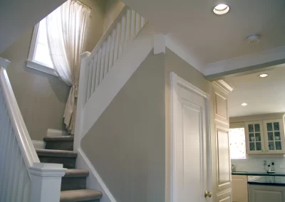 kitchen and stairway in a freshly painted house with two tone white and tan paint, white on trim