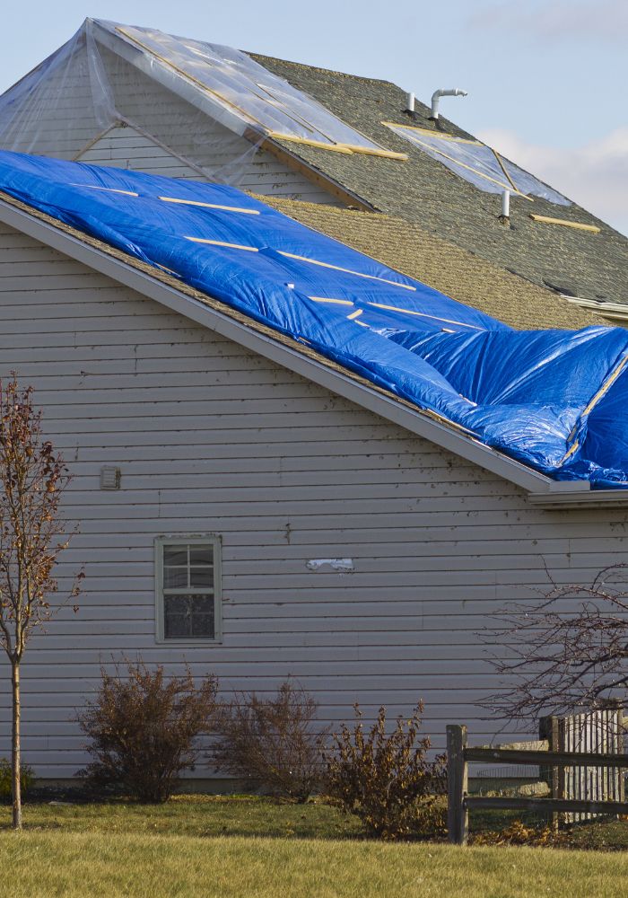 House damaged in a natural disaster, roof damage, window damage